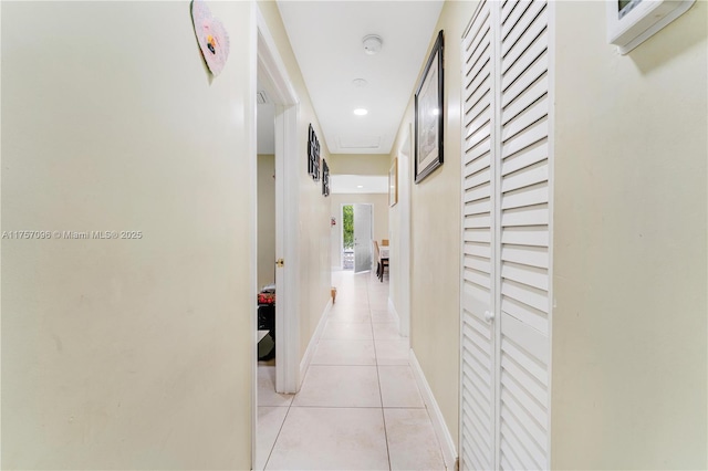 corridor featuring light tile patterned floors, recessed lighting, and baseboards