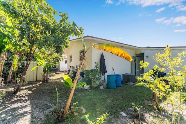 view of side of home featuring fence and central air condition unit