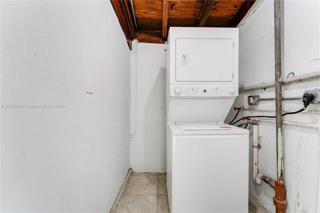 washroom featuring laundry area, light tile patterned floors, and stacked washer / dryer