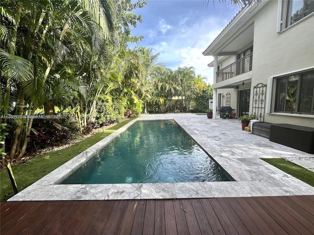 outdoor pool with a deck and a patio