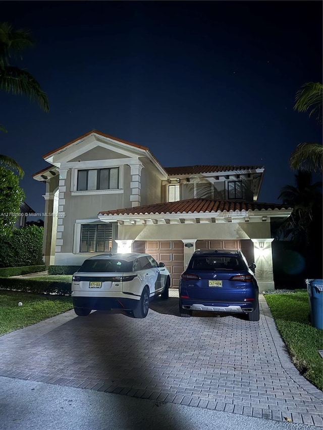 view of front of property with decorative driveway, a garage, and stucco siding