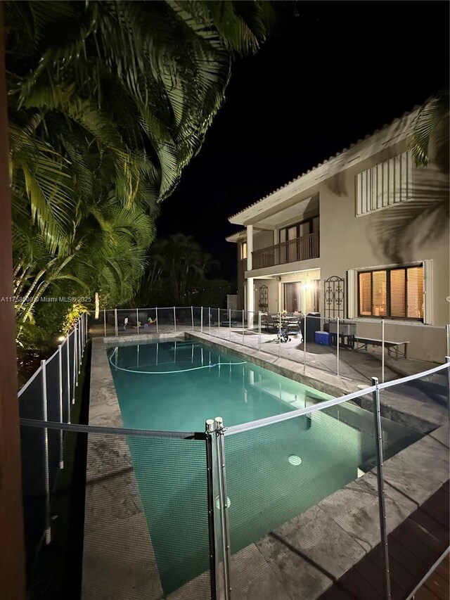 pool at twilight featuring a fenced in pool, a patio, and fence