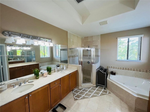 bathroom with a sink, a jetted tub, a shower stall, tile patterned flooring, and double vanity