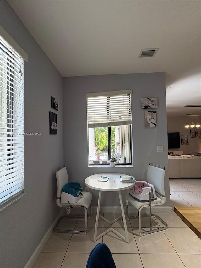 dining area featuring light tile patterned floors, visible vents, and baseboards