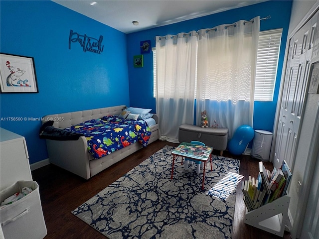 bedroom featuring a closet, baseboards, and wood finished floors