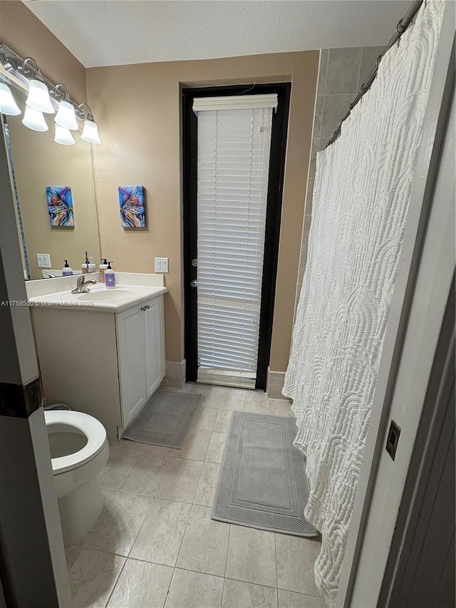 full bathroom with tile patterned floors, toilet, vanity, and a textured ceiling