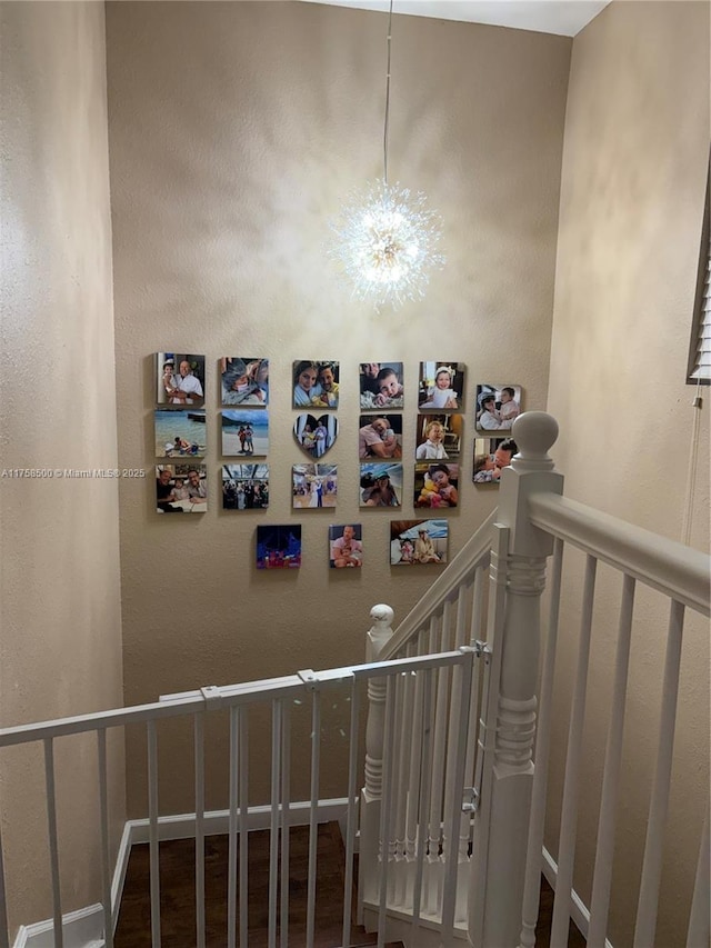 stairs with a notable chandelier