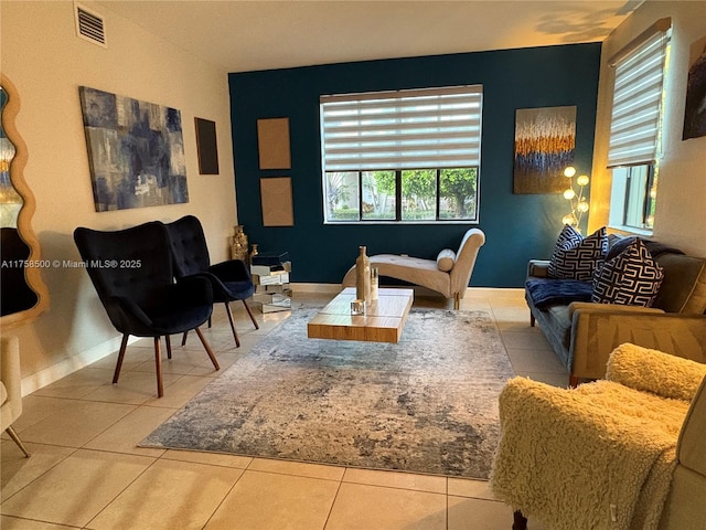 living area featuring tile patterned floors, visible vents, and baseboards