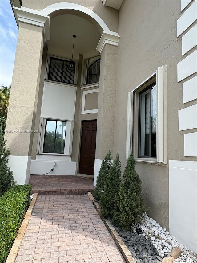 doorway to property featuring stucco siding