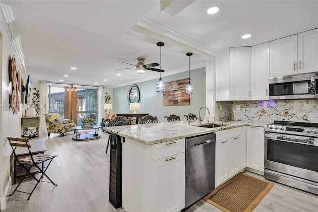 kitchen featuring a sink, white cabinets, appliances with stainless steel finishes, decorative backsplash, and crown molding