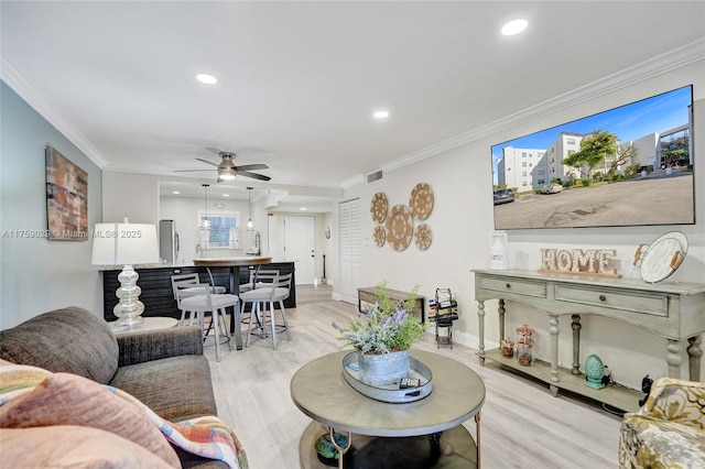 living room with light wood-type flooring, visible vents, crown molding, and recessed lighting