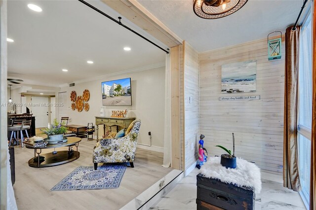 sitting room featuring recessed lighting, wood walls, wood finished floors, baseboards, and crown molding