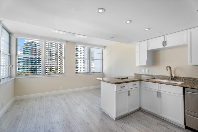 kitchen with recessed lighting, a peninsula, a sink, stainless steel dishwasher, and light wood-type flooring