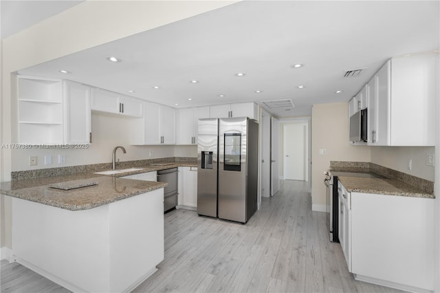 kitchen featuring a peninsula, a sink, visible vents, appliances with stainless steel finishes, and open shelves