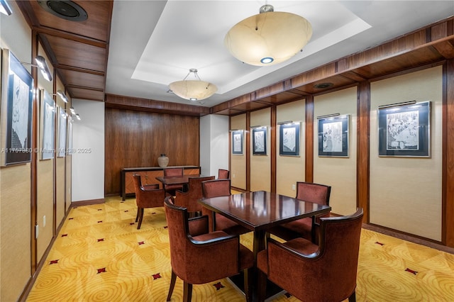 dining room with a raised ceiling and baseboards