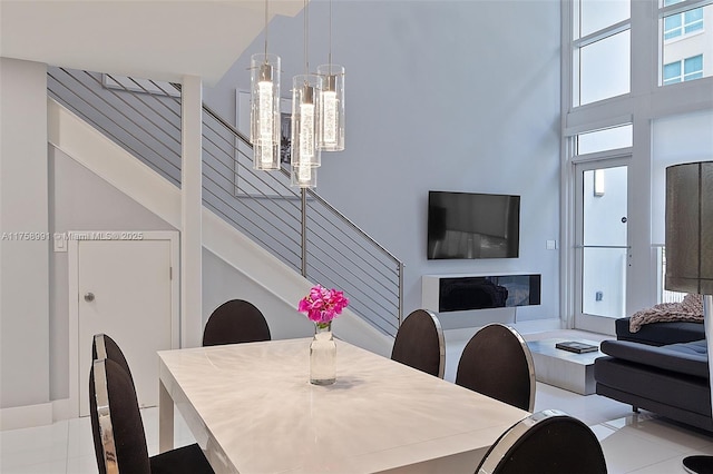 dining space with a towering ceiling and stairs