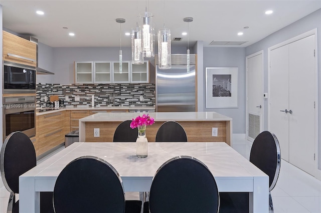 kitchen featuring tasteful backsplash, visible vents, modern cabinets, glass insert cabinets, and built in appliances