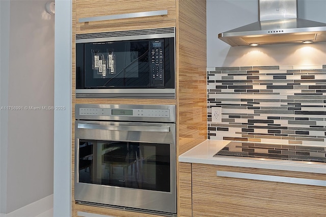2020 N Bayshore Dr Unit Th 104, Miami, FL 33137 - kitchen view of wall chimney exhaust hood, stainless steel oven, built in microwave, tasteful backsplash, and black electric cooktop