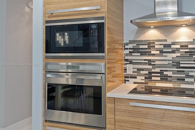 2020 N Bayshore Dr Unit Th 104, Miami, FL 33137 - kitchen view of wall chimney exhaust hood, stainless steel appliances, decorative backsplash, and light countertops