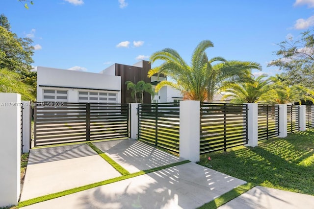 view of gate featuring a fenced front yard and a lawn