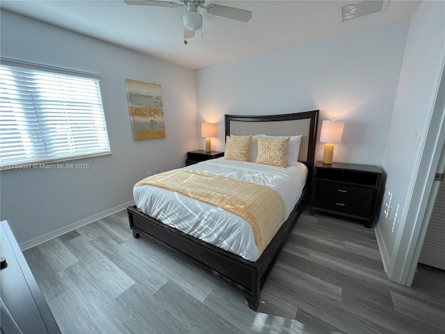 bedroom featuring ceiling fan, wood finished floors, and baseboards