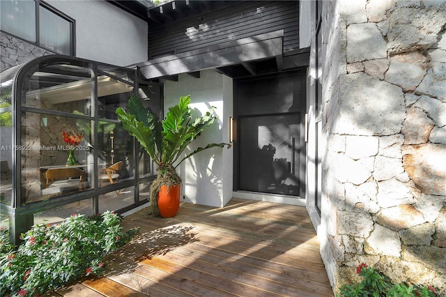 property entrance featuring stone siding and stucco siding