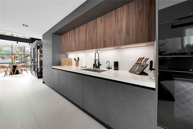 kitchen featuring expansive windows, modern cabinets, light countertops, and a sink