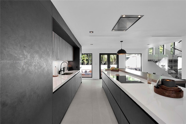 kitchen with dark cabinets, modern cabinets, black electric stovetop, and a sink