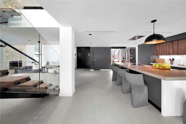 kitchen featuring a kitchen bar, modern cabinets, light countertops, and decorative light fixtures