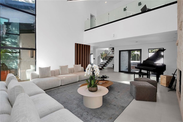 living room with a high ceiling, a fireplace, and stairway