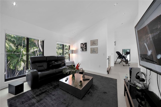 living area with baseboards and high vaulted ceiling