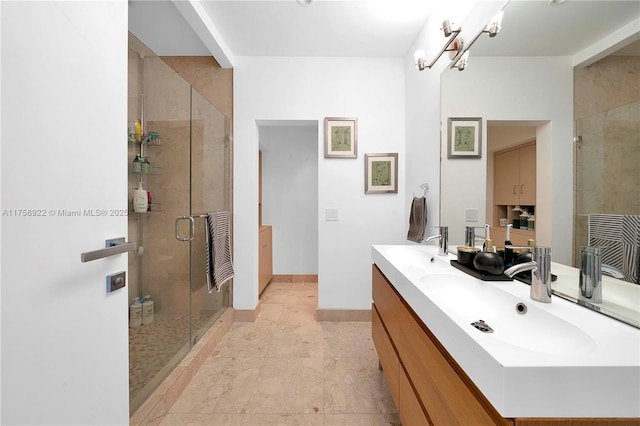 full bathroom featuring baseboards, double vanity, a sink, and a shower stall