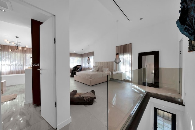 bedroom featuring a towering ceiling and marble finish floor