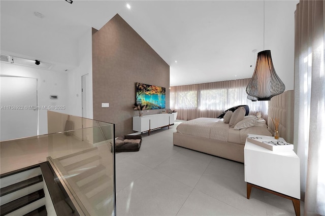 bedroom with light tile patterned floors and high vaulted ceiling