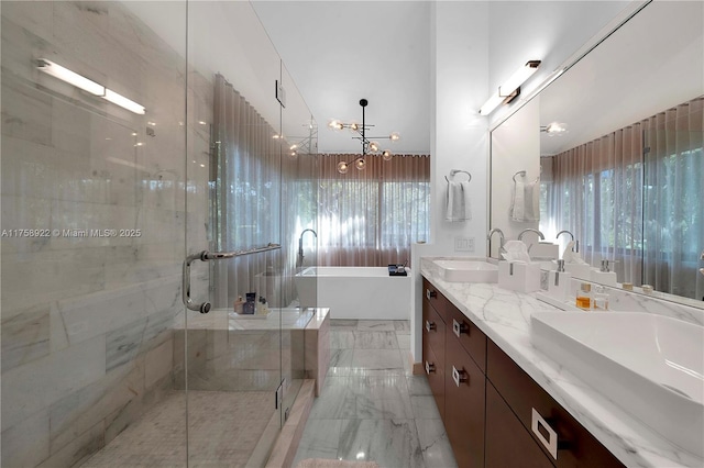 bathroom featuring a freestanding tub, a sink, marble finish floor, double vanity, and a stall shower