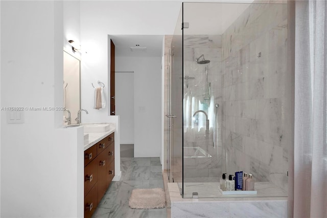 full bath with marble finish floor, a tile shower, and vanity