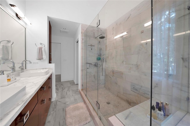 bathroom with double vanity, visible vents, marble finish floor, a shower stall, and a sink