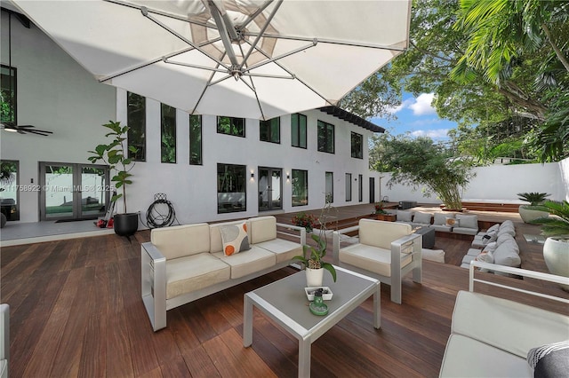 wooden terrace featuring fence, outdoor lounge area, and french doors