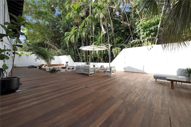 wooden terrace with an outdoor living space