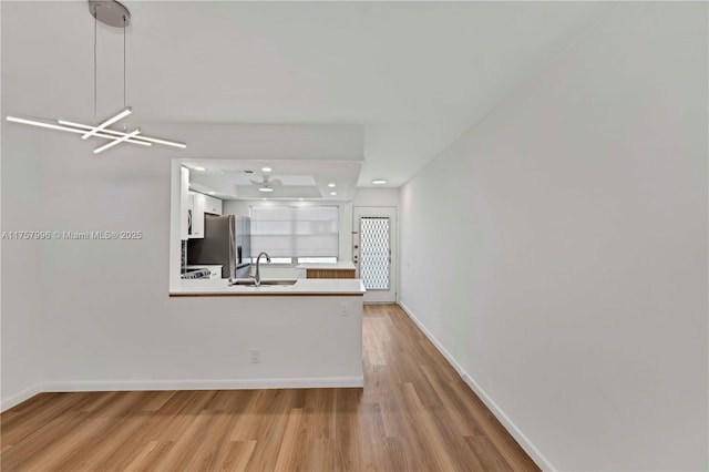 interior space with a sink, baseboards, and wood finished floors