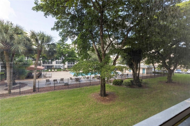 view of property's community with fence and a yard