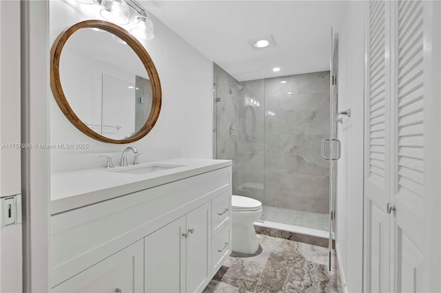 full bath with a stall shower, toilet, marble finish floor, vanity, and a closet