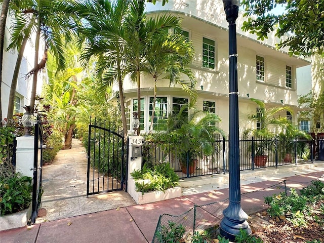 exterior space with a fenced front yard, a gate, and stucco siding