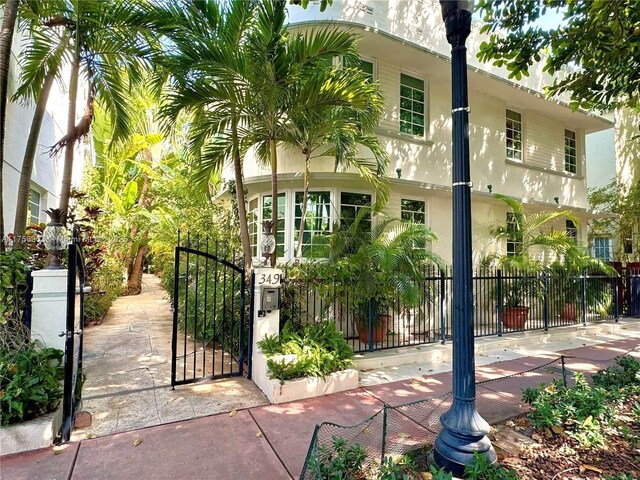 exterior space featuring stucco siding, a fenced front yard, and a gate