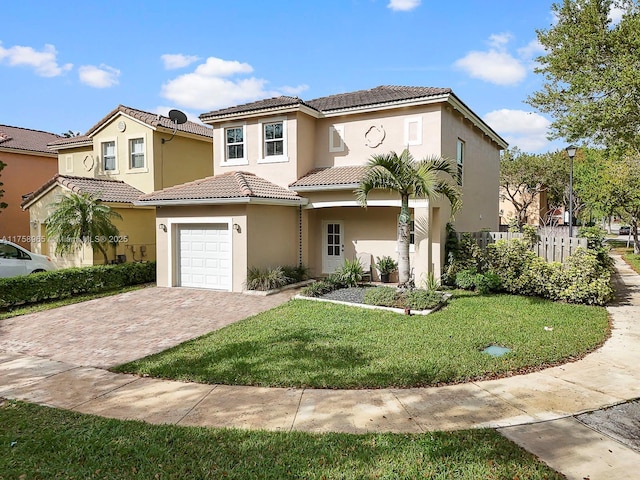 mediterranean / spanish home with a garage, a tiled roof, decorative driveway, a front lawn, and stucco siding