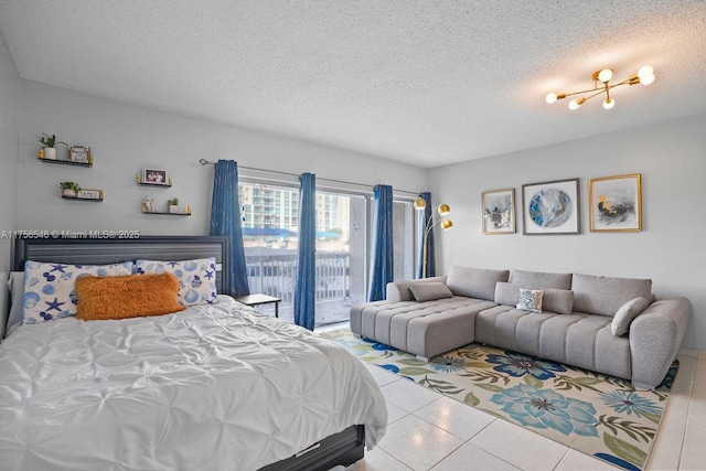 tiled bedroom featuring access to outside and a textured ceiling