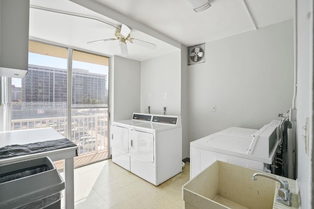 shared laundry area featuring a ceiling fan, a view of city, a sink, and washer and clothes dryer