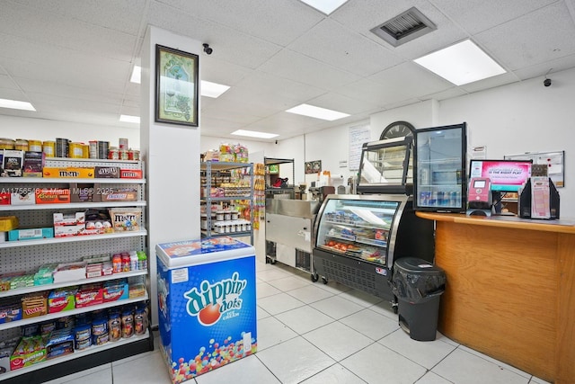 interior space featuring a drop ceiling, tile patterned flooring, and visible vents