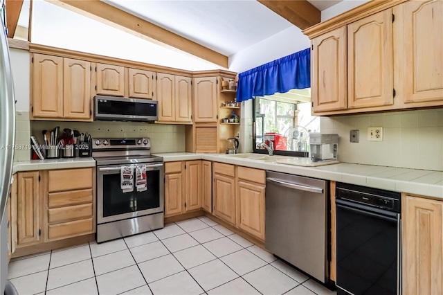 kitchen with tile counters, light brown cabinets, and stainless steel appliances