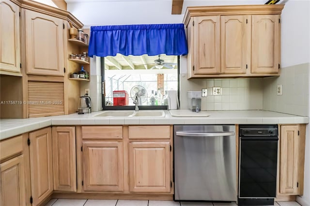 kitchen with light brown cabinetry, a sink, decorative backsplash, and stainless steel dishwasher